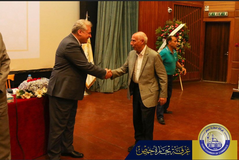 محافظ حمص يصافح محمد حجو أثناء تسليمه الجائزة.