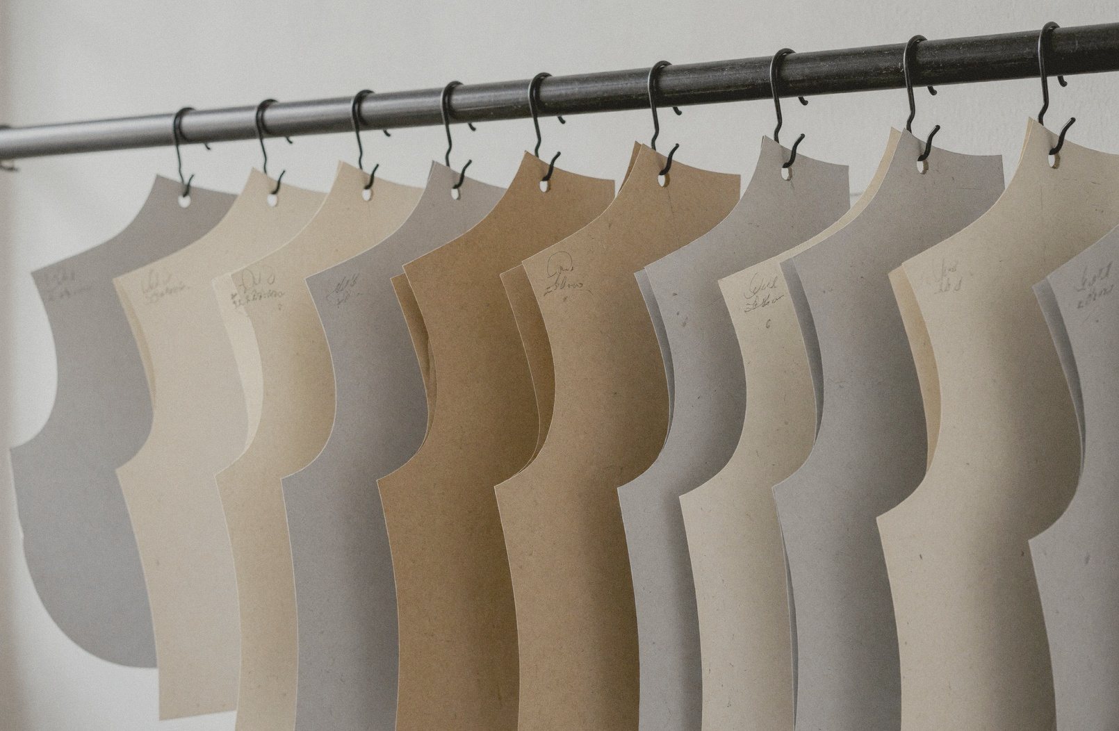 Card patterns hanging on a rail in the atelier